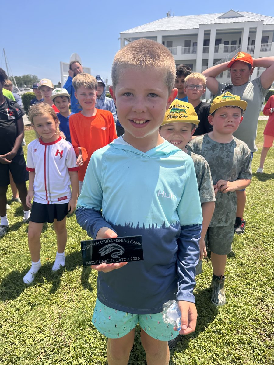 Camper holding his Most Unique Catch plaque with the rest of the campers behind him at the Friday awards