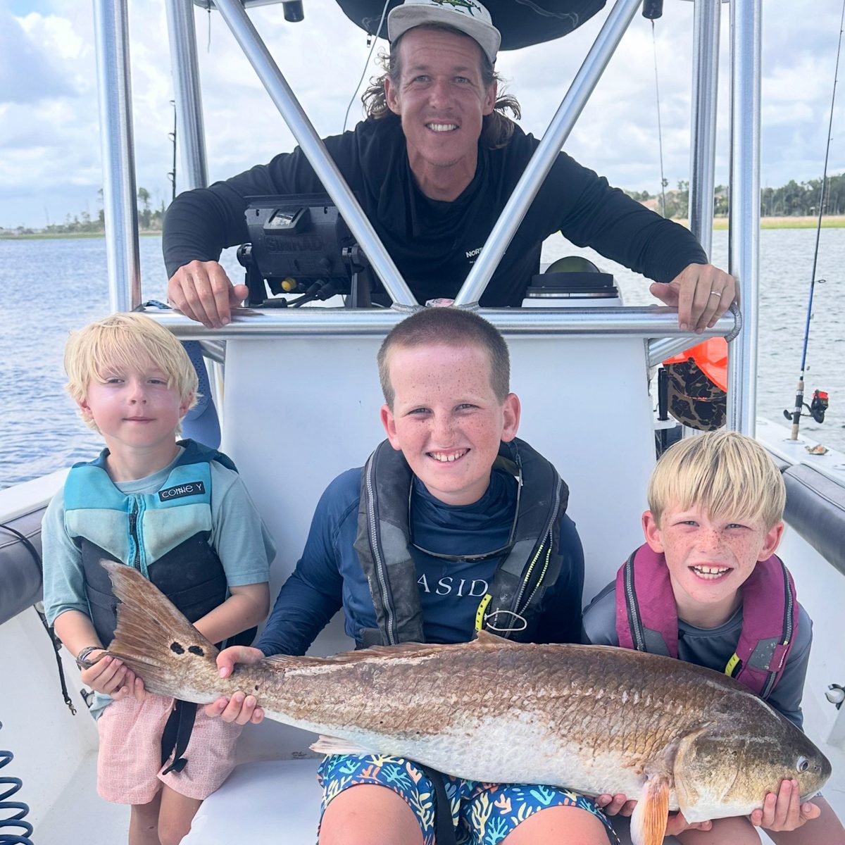Capt. Joe Carraway with three day campers and a bull redfish